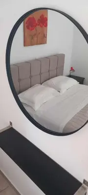 a bedroom with a large mirror above a bed at Emmanuel apartment in Agia Marina Nea Kydonias