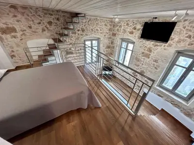 a bedroom with a bed and a tv on a wall at Kazalakis Chania Harbor Roof top retreat in Chania Town