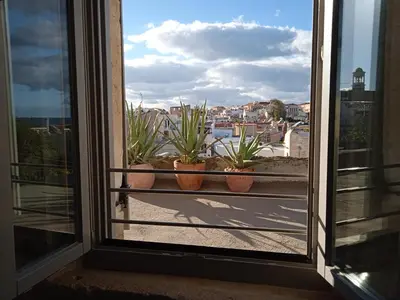 a window with potted plants on a balcony at Kazalakis Chania Harbor Roof top retreat in Chania Town