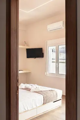 a bedroom with a bed and a tv on the wall at Serena in Chania Town