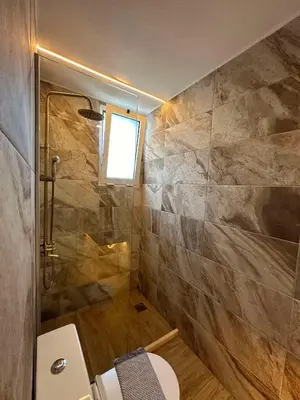 a bathroom with a shower and a toilet and a window at Serena in Chania Town