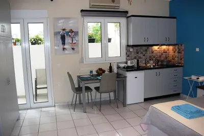 a kitchen with a table and chairs in a room at The Blue Studio, 1 min walk from Kalamaki beach in Kalamaki Chanion