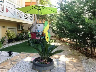 a patio with a table and a green umbrella at The Blue Studio, 1 min walk from Kalamaki beach in Kalamaki Chanion