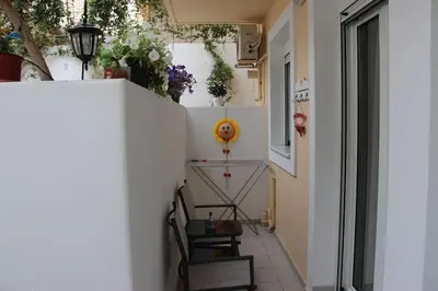 a hallway of a house with chairs and flowers at The Blue Studio, 1 min walk from Kalamaki beach in Kalamaki Chanion