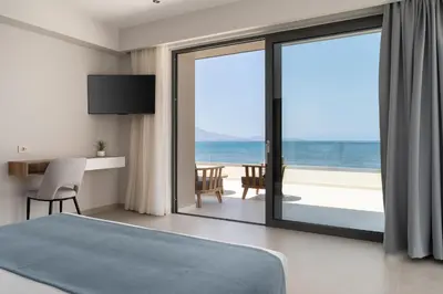 a bedroom with a bed and a view of the ocean at LUXURY VILLA EOS Beachfront 20 metres from the sea in Nopíyia