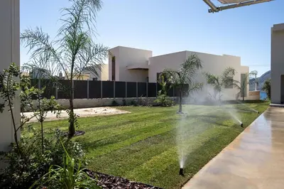 a house with a lawn spraying the grass at Punto De Vista Luxury Villas in Korakiaí