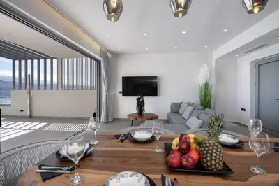 a living room with a table with fruit on it at Punto De Vista Luxury Villas in Korakiaí