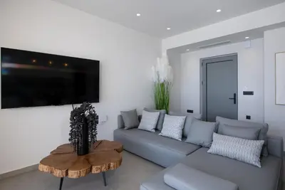 a living room with a couch and a table at Punto De Vista Luxury Villas in Korakiaí