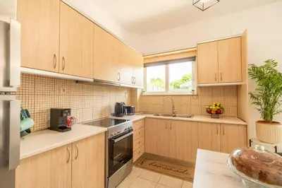 a kitchen with wooden cabinets and a sink at Ampelos in Perivólia