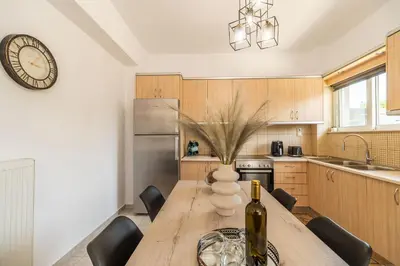 a kitchen with a wooden table with a bottle of wine at Ampelos in Perivólia