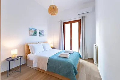 a white bedroom with a bed and a window at Corso Venezia Luxury Apartment 3BR in Chania Town