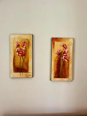 two paintings of red roses on a wall at Yasemi Chania Residences in Chania Town