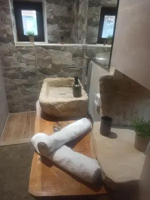 a bathroom with a sink and a towel dispenser at Kourtsa villas in Vafés