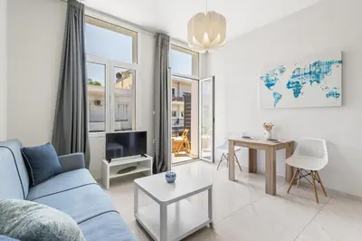 a living room with a blue couch and a tv at Central Bliss Apartment in Chania Town