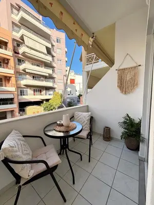 a balcony with a table and chairs on a building at Lynne's Harmony Chania Beach Studio in Chania Town