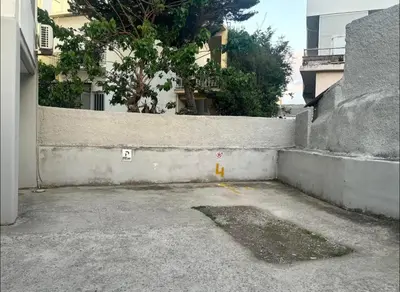 an empty parking lot next to a concrete wall at Lynne's Harmony Chania Beach Studio in Chania Town