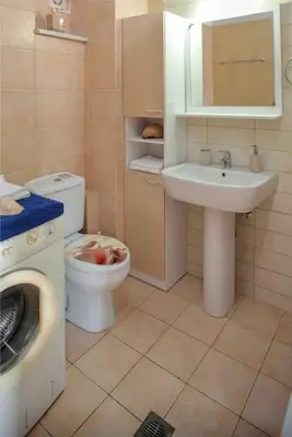 a bathroom with a sink toilet and a washing machine at VALENA COZY MAISONETTE (15 min-ELAFONISI BEACH) in Élos