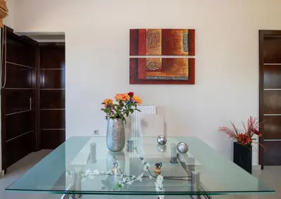 a glass table with a vase with flowers on it at Socrates Holidays Apt. 1 with Pool near the Beach in Kamisianá