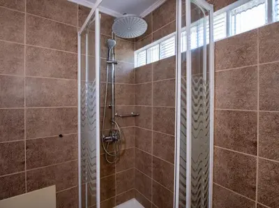 a shower with a glass door in a bathroom at Socrates Holidays Apt. 1 with Pool near the Beach in Kamisianá