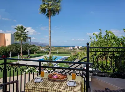 a table with a bowl of fruit on a balcony at Socrates Holidays Apt. 1 with Pool near the Beach in Kamisianá