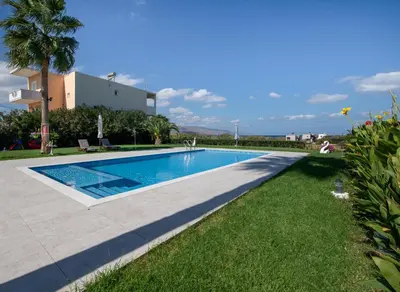 a swimming pool in front of a villa at Socrates Holidays Apt. 1 with Pool near the Beach in Kamisianá