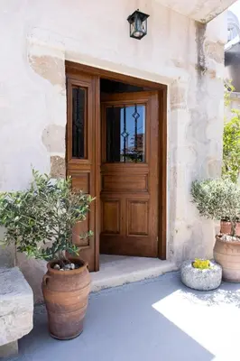 a wooden door of a house with potted plants at The Fabrica Falasarna in Plátanos