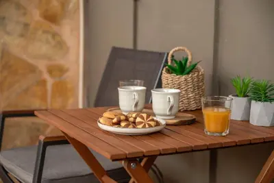 a wooden table with a plate of food and drinks on it at Modern Studio 2 with a Yard in Chania Town