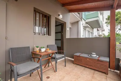 a patio with two chairs and a table and a bench at Modern Studio 2 with a Yard in Chania Town