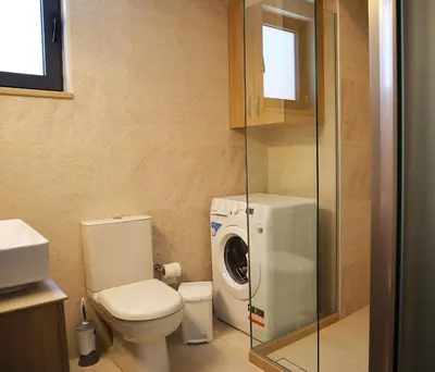 a bathroom with a toilet and a washing machine at Dimitriοs Stone House in Chania Town