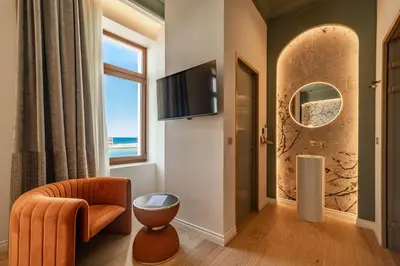 a living room with a tv and a chair and a window at MiraVita Boutique Hotel - Adults Only in Chania Town