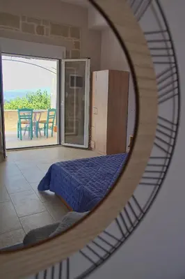 a mirror reflecting a bedroom with a bed and a table at Mulberry Hill - amazing panoramic views - Kissamos in Kissamos