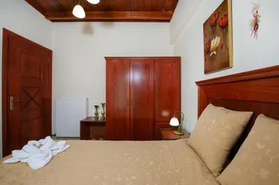 a bedroom with a bed with a wooden headboard at Socrates Holidays Apt. 2 with Pool near the Beach in Plataniás