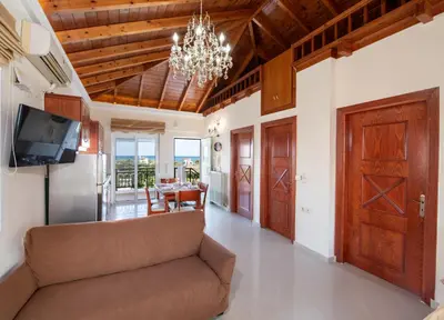 a living room with a couch and a chandelier at Socrates Holidays Apt. 2 with Pool near the Beach in Plataniás