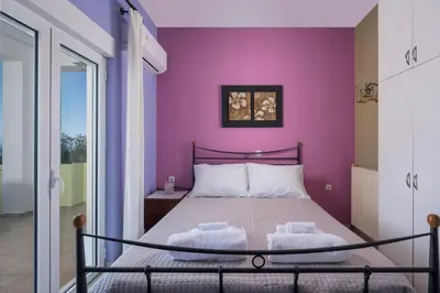 a bedroom with a purple wall and a bed at Mystique Sunset View in Chania Town