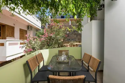 a table and chairs on a balcony with flowers at Mystique Sunset View in Chania Town