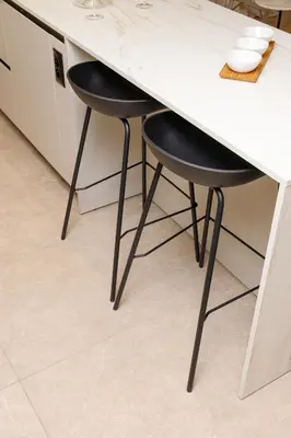 a kitchen with two black stools under a counter at CRETA ELENA SUITE in Chania Town