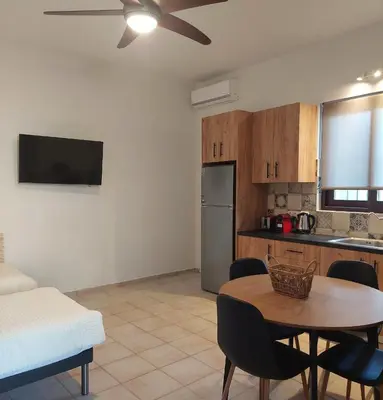 a living room with a table and a kitchen at Elaion Apartments in Kántanos