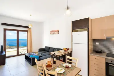 a kitchen and living room with a table and a refrigerator at Livaniana Panoramic View house 2 in Livanianá