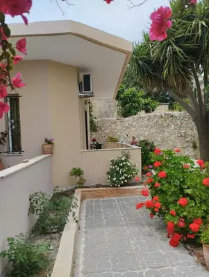 a house with flowers in front of a walkway at Liza's Place in Metókhion