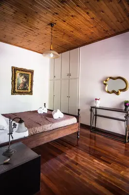 a bedroom with a large bed and a wooden ceiling at Liza's Place in Metókhion