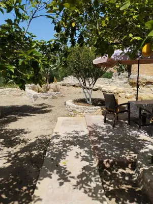 a patio with a table and a chair under a tree at Liza's Place in Metókhion