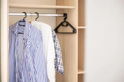 a closet with a blue and white shirt on a rack at Finikas Resort Sfakia - Seaside Rooms in Loutro