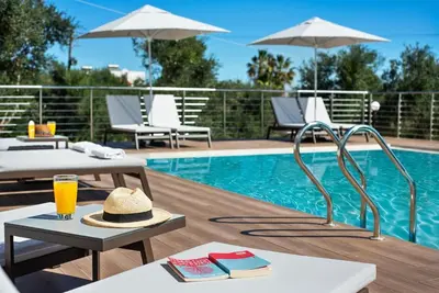 a pool with a table with a hat and a drink at Kera Green Villa in Kalyves