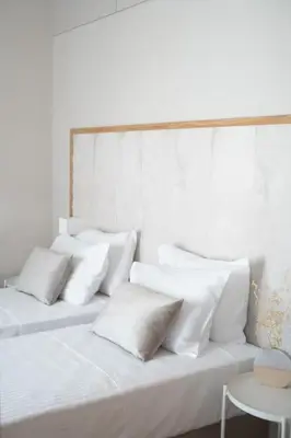 a white room with two beds with white pillows at Riviera Seafront Balcony in Evthími