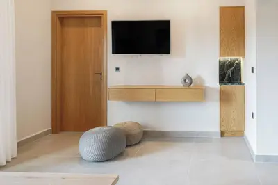 a living room with a television on a wall at Riviera Seafront Balcony in Evthími