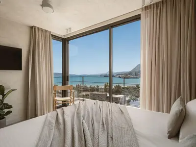 a bedroom with a bed and a large window at Villa Albero - Sea View Escape in Souda