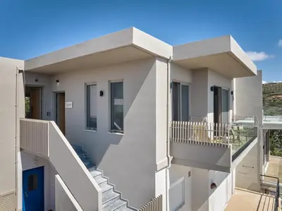 a white house with stairs and a balcony at Nami Suites - Alenia in Chania Town