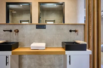a bathroom with two sinks and two mirrors at Nami Suites - Alenia in Chania Town