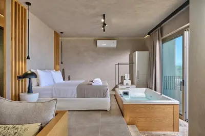 a hotel room with a bed and a tub at Nami Suites - Alenia in Chania Town