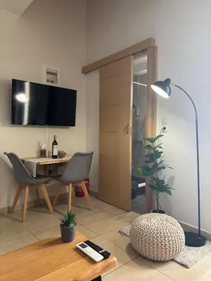 a living room with a table and a desk with a lamp at Duplex apartment city center in Chania Town
